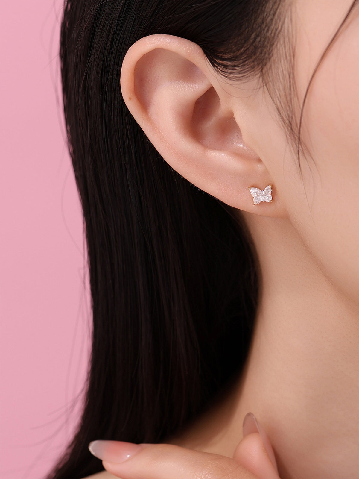 Dainty butterfly-cut lab-grown diamond stud earring on the ear, D-E VS