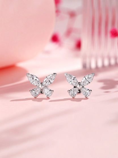 Butterfly lab-grown diamond stud earrings on a soft pink backdrop