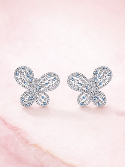 Papillon butterfly diamond stud earrings, front view on pink marble