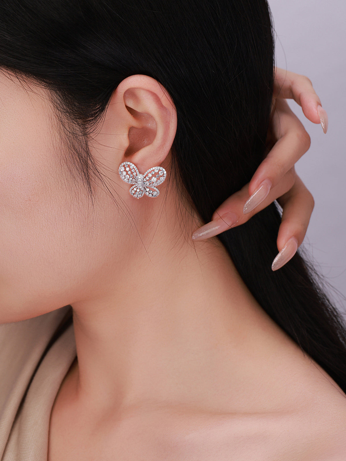 Close-up of Papillon butterfly diamond stud earring on model