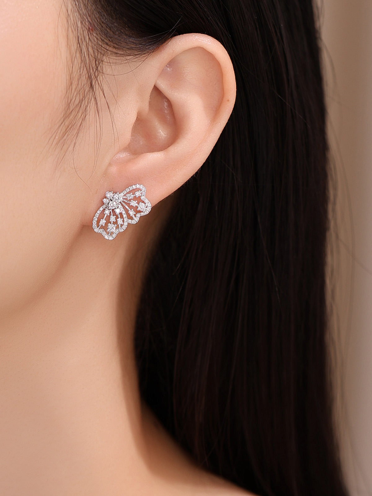 Papillon butterfly wing diamond earring worn on the ear, side view