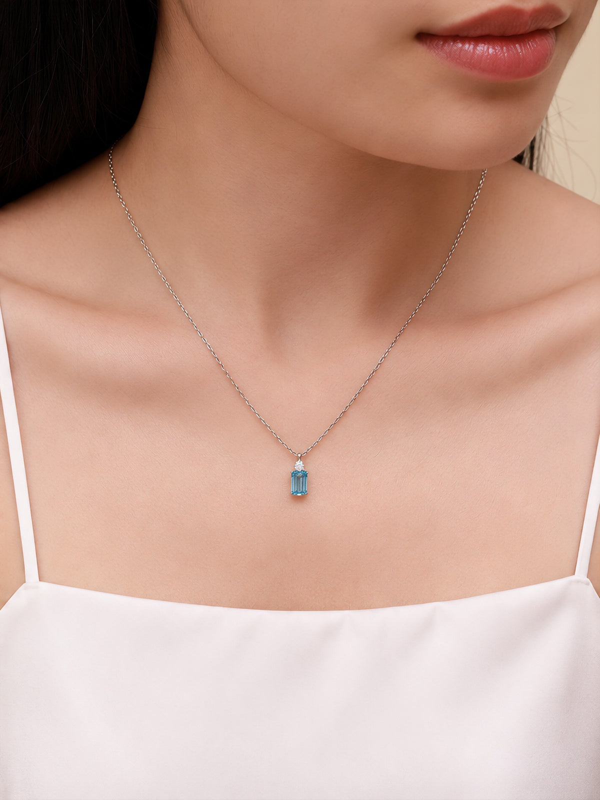 Model wearing the DANFÉE Parfum blue diamond necklace at the collarbone