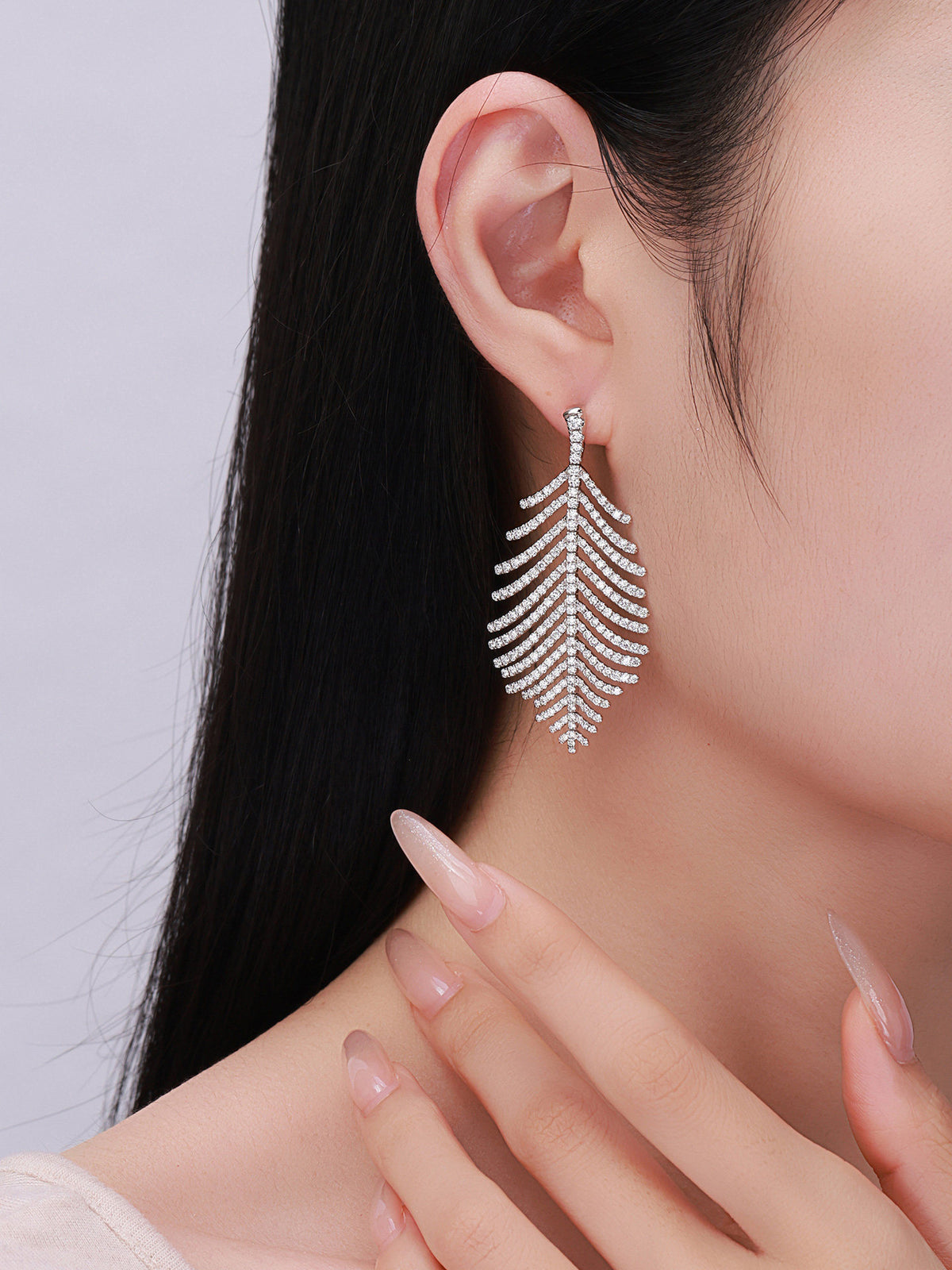 Model wearing the large Plume feather lab-grown diamond drop earring