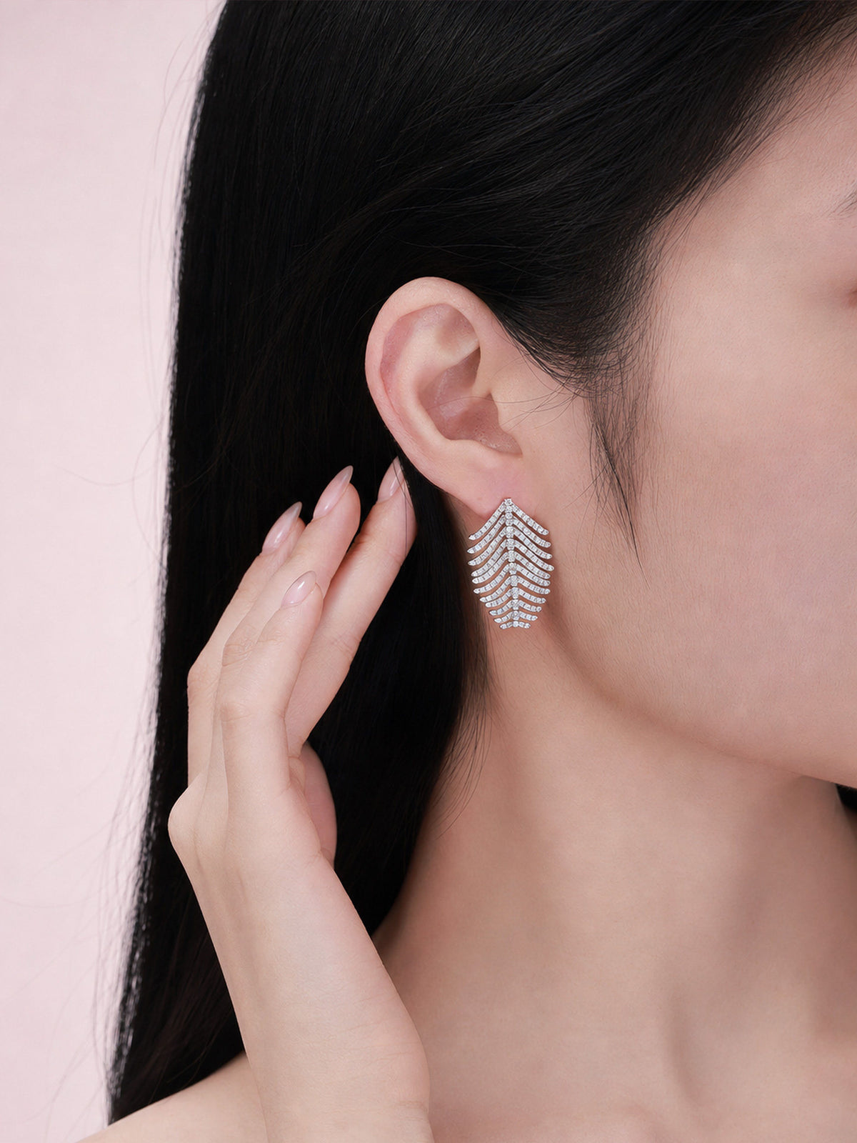 Model wearing the small Plume feather diamond earring in 18K white gold