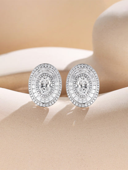 Oval lab-grown diamond halo earrings with baguette ring on a sand-toned set