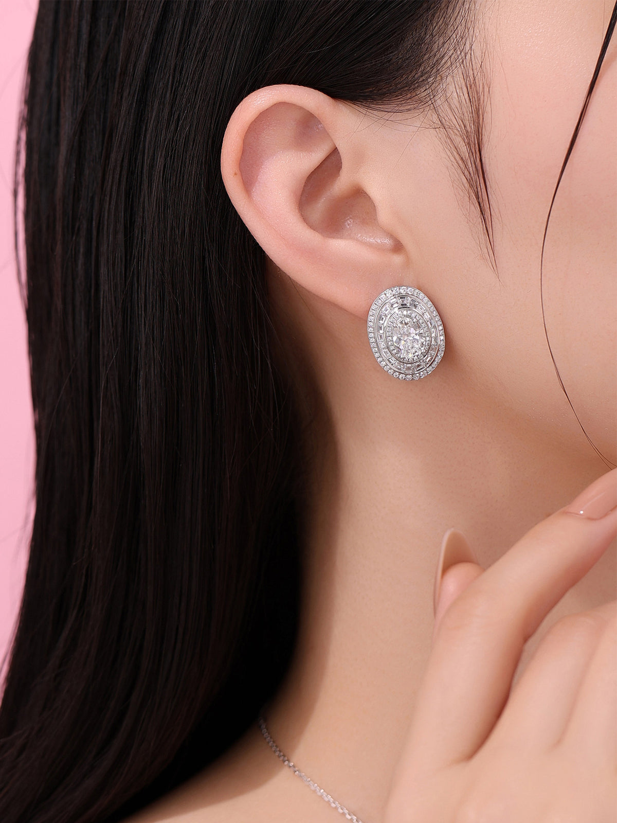 Model wearing the oval lab-grown diamond triple-halo earring, right ear