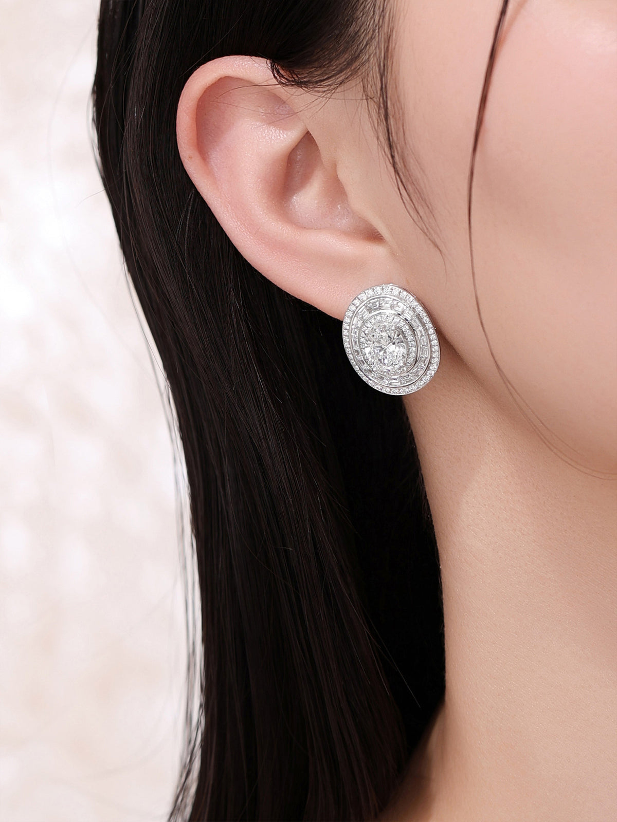 Close-up of the 4 carat oval diamond halo earring worn on the ear