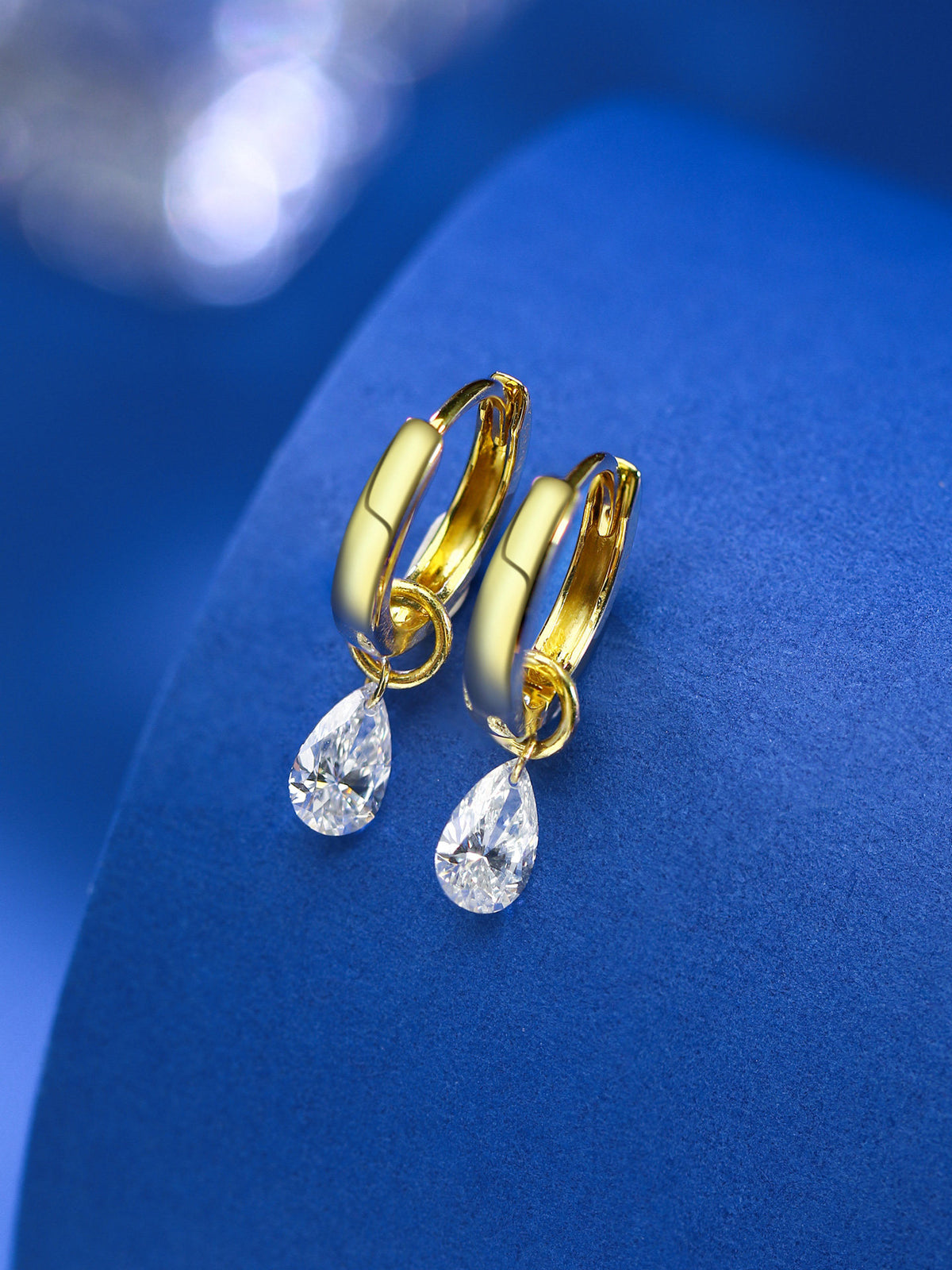 Pear-cut lab-grown diamond drop huggies in 18K gold on blue velvet