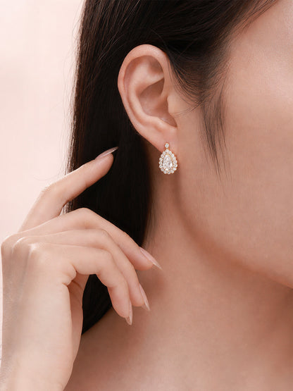 Pear-cut lab-grown diamond halo drop earring worn on the ear
