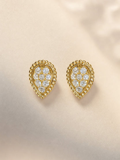 Pear-shaped lab-grown diamond stud earrings with beaded 18K gold frame on ivory satin