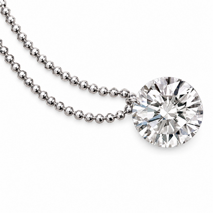 Round diamond pendant and white gold bead chain detail on white; digitally retouched supplier image