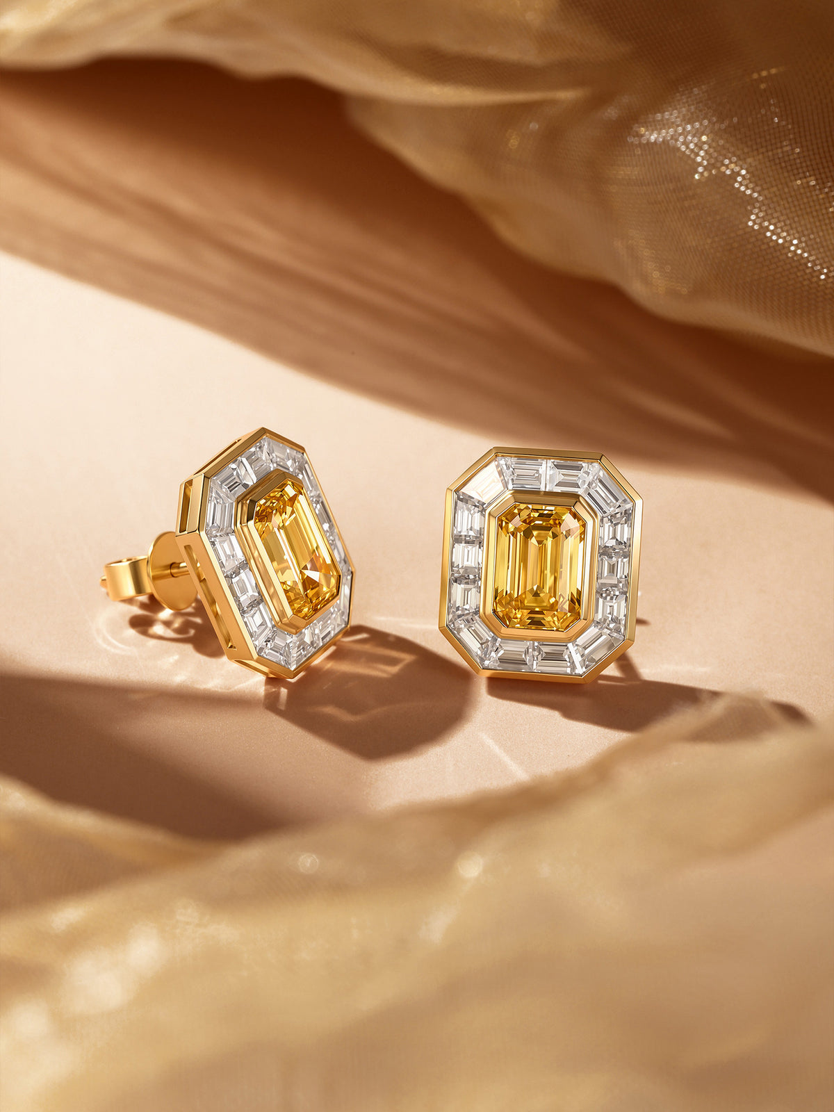 Emerald-cut yellow diamond earrings with baguette halo on gold silk