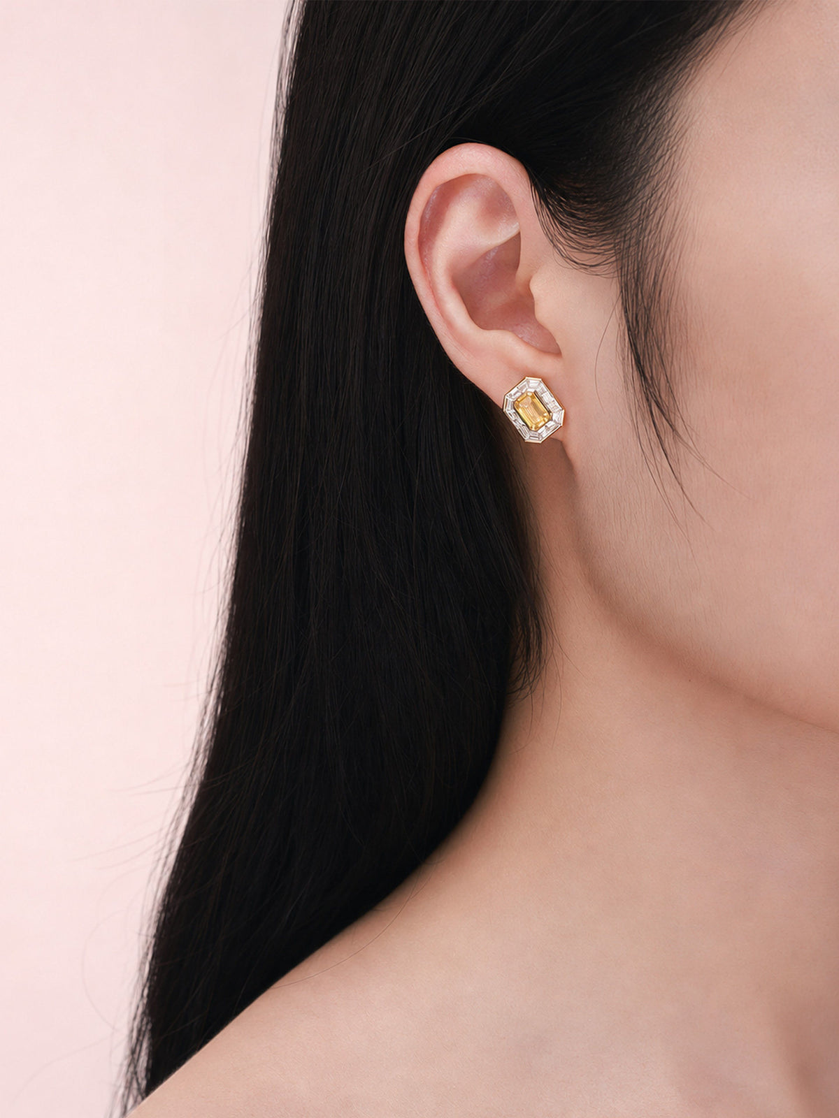 Side profile of model wearing 18K gold yellow diamond halo stud earring