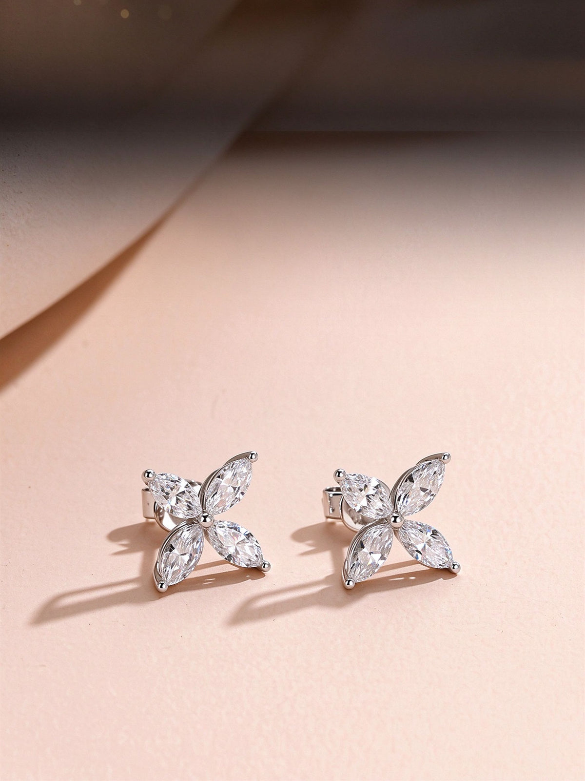 Pair of four-petal marquise lab-grown diamond stud earrings in platinum on a blush backdrop
