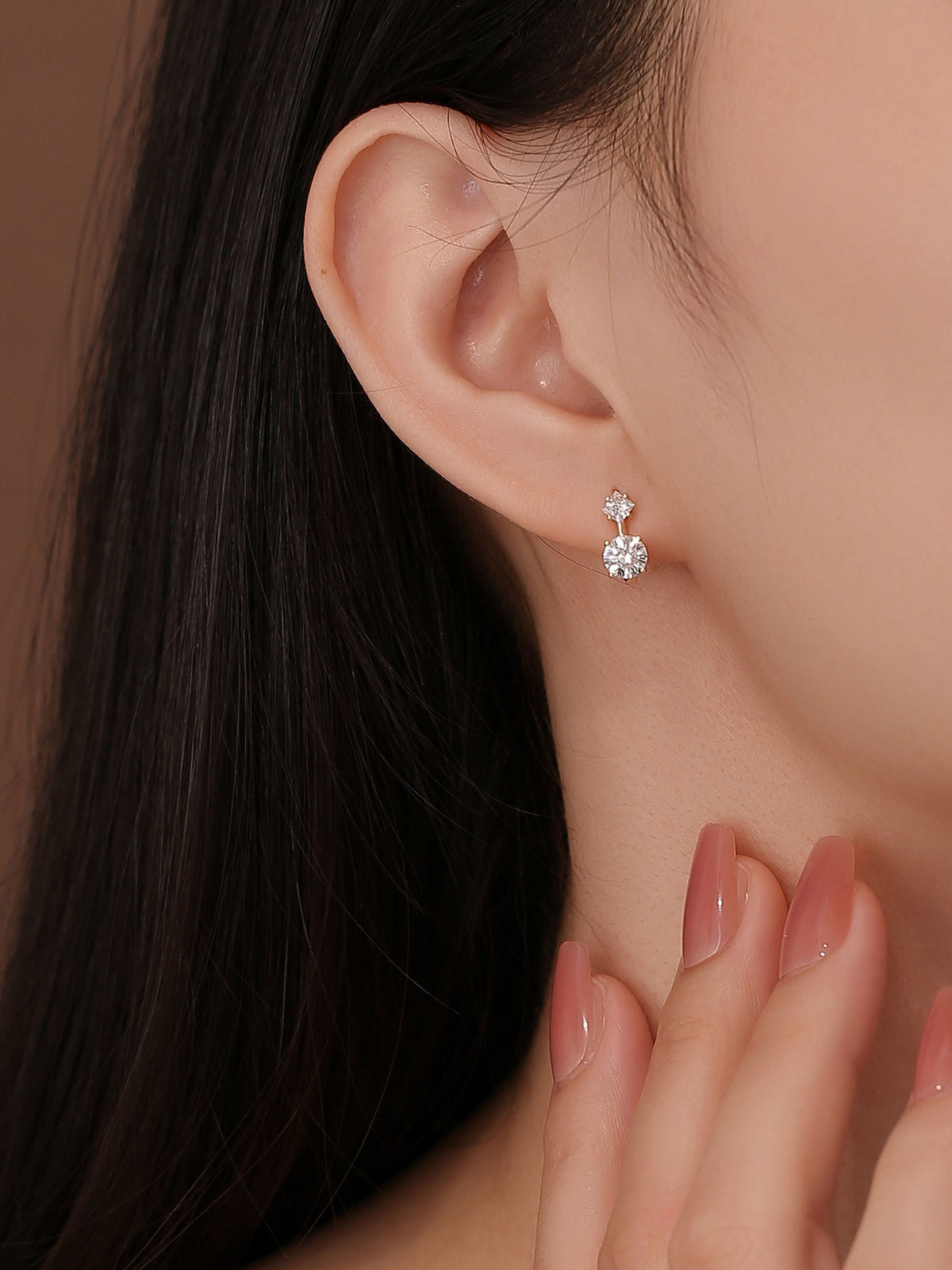 Close-up of two-stone lab-grown diamond huggie earrings on the ear