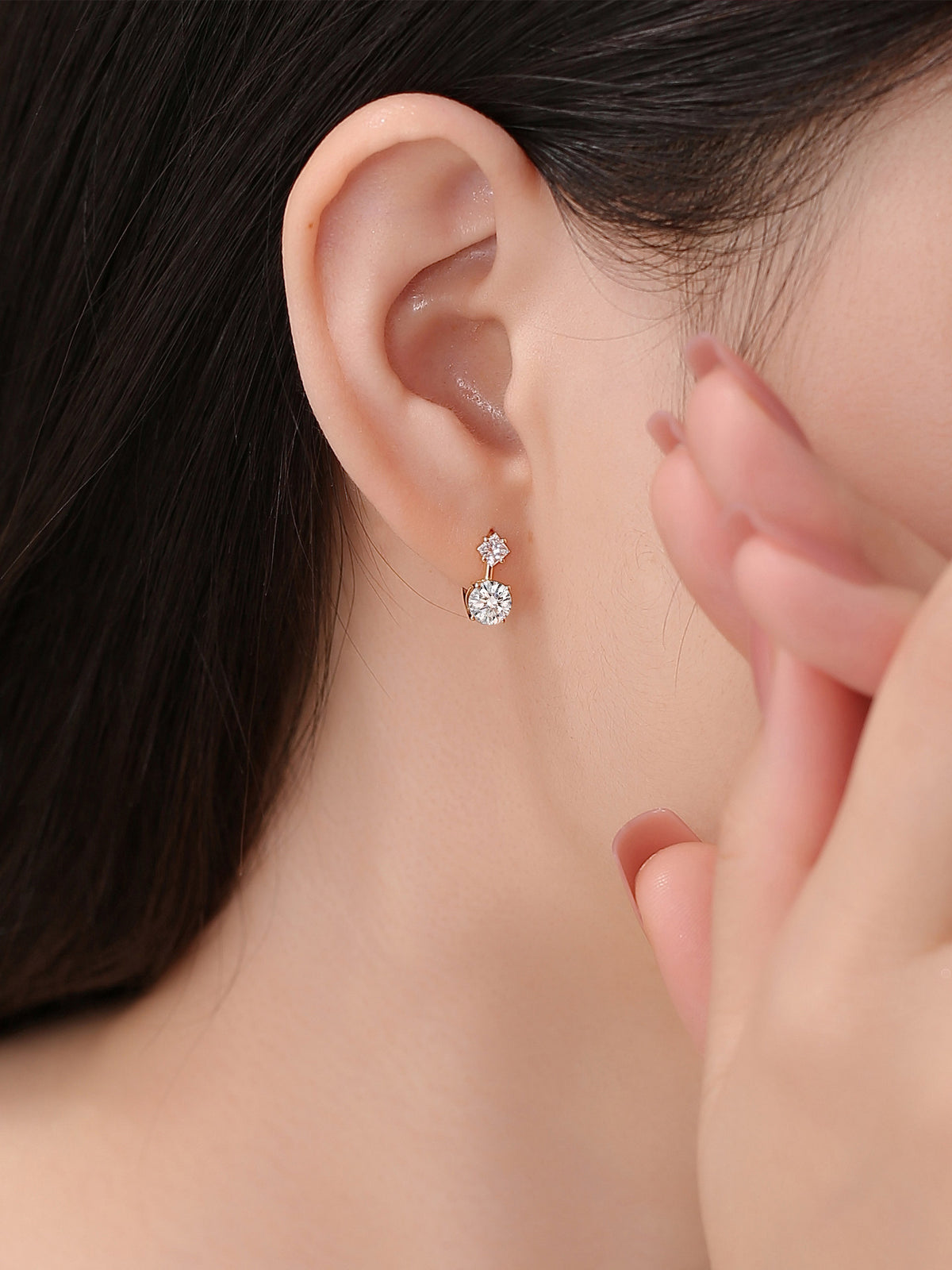 Princess and round diamond huggie earrings worn on the lobe
