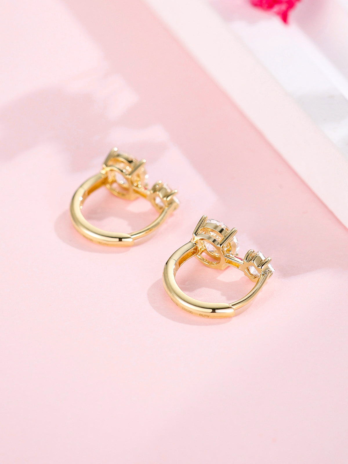 Back view of the 18K gold huggie earrings showing the hinged closure and Au750 hallmark