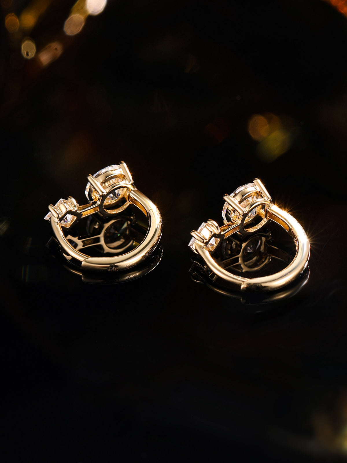 Four-claw settings and hinged hoop of the 18K gold diamond huggie earrings