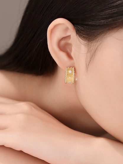 Close-up of Étoile brushed gold diamond half-hoop earring on the ear