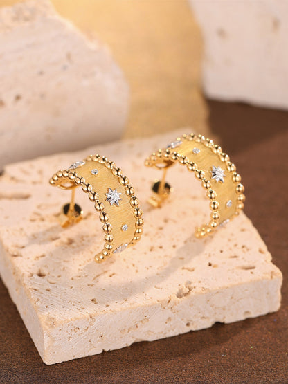 Étoile 18K gold star diamond half-hoop earrings on travertine
