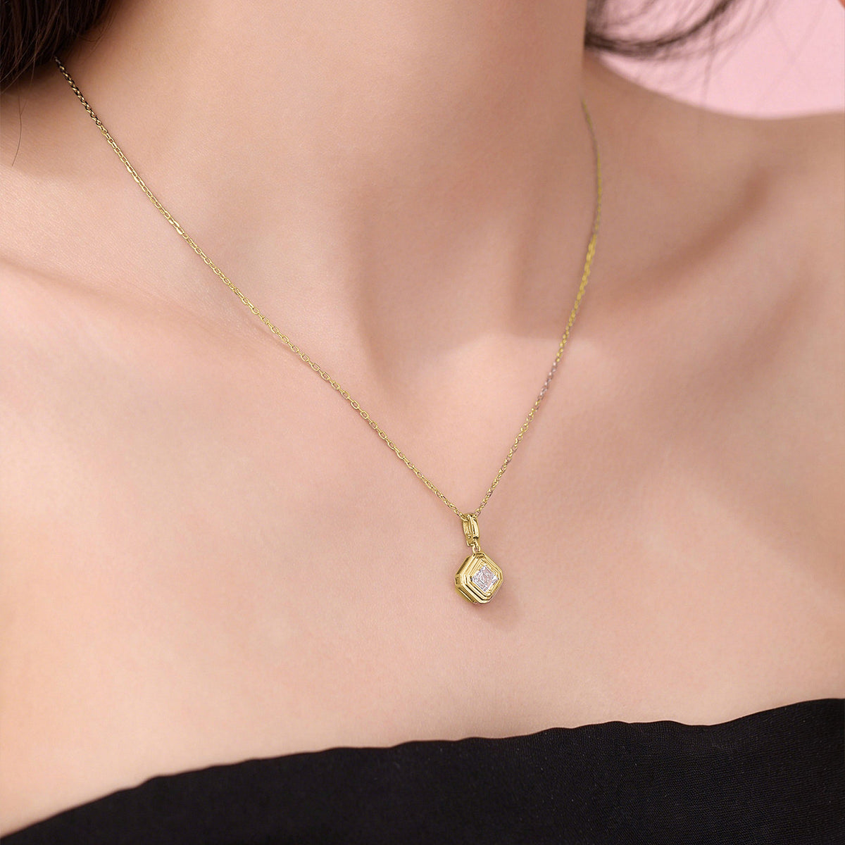 Close-up of the DANFÉE Deco Asscher pendant necklace in 18K yellow gold on the neckline