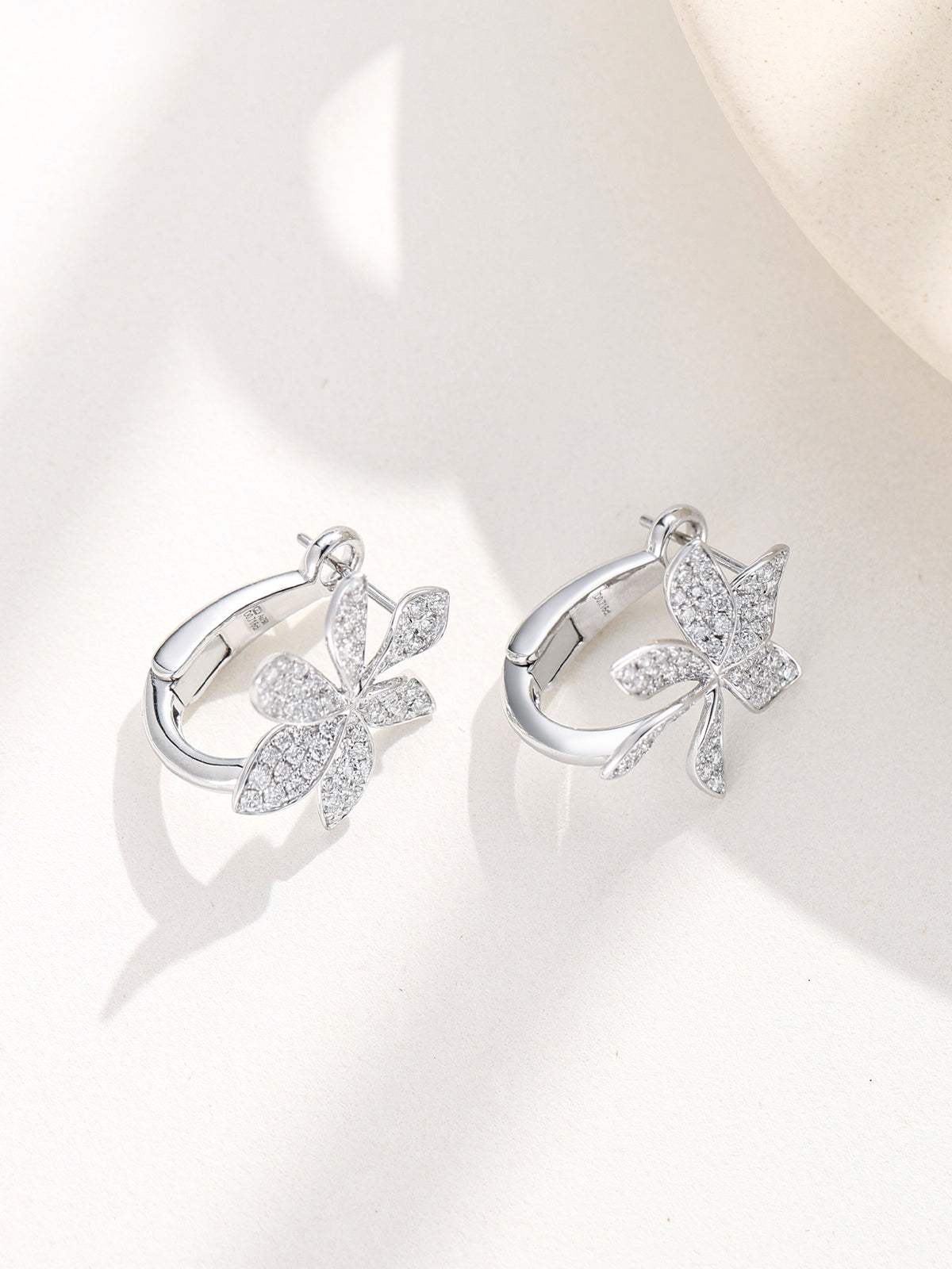 Flower huggie earrings shown open with curved back