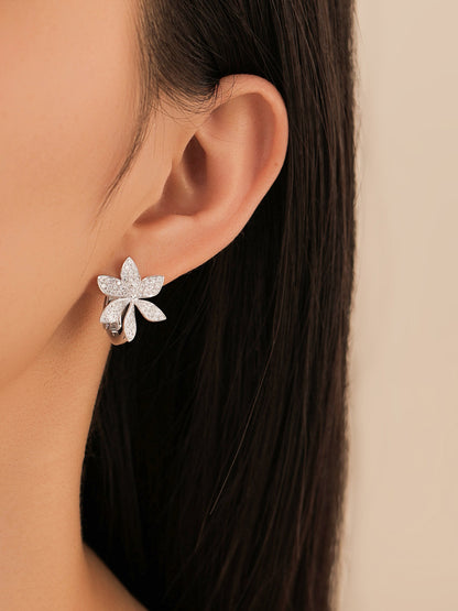 Magnolia diamond flower huggie earring worn on the ear