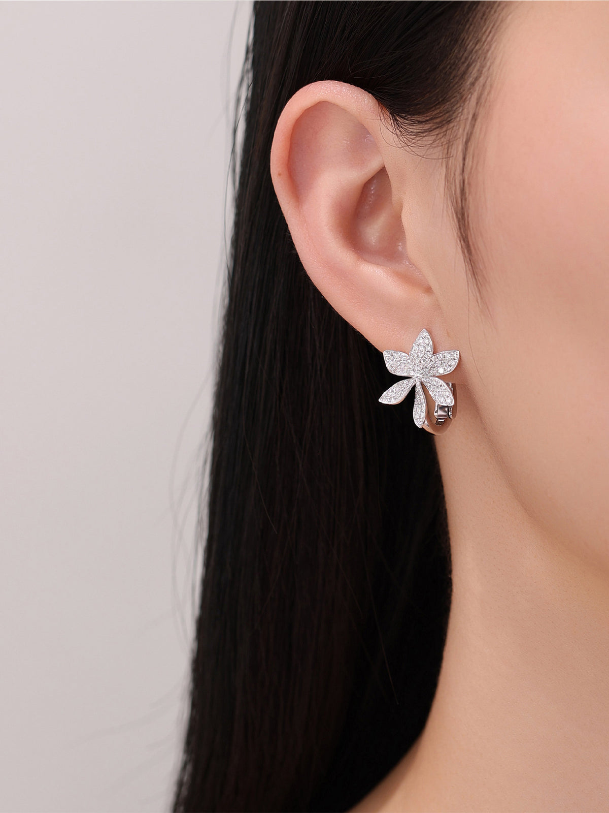 Lab-grown diamond flower huggie earring on model