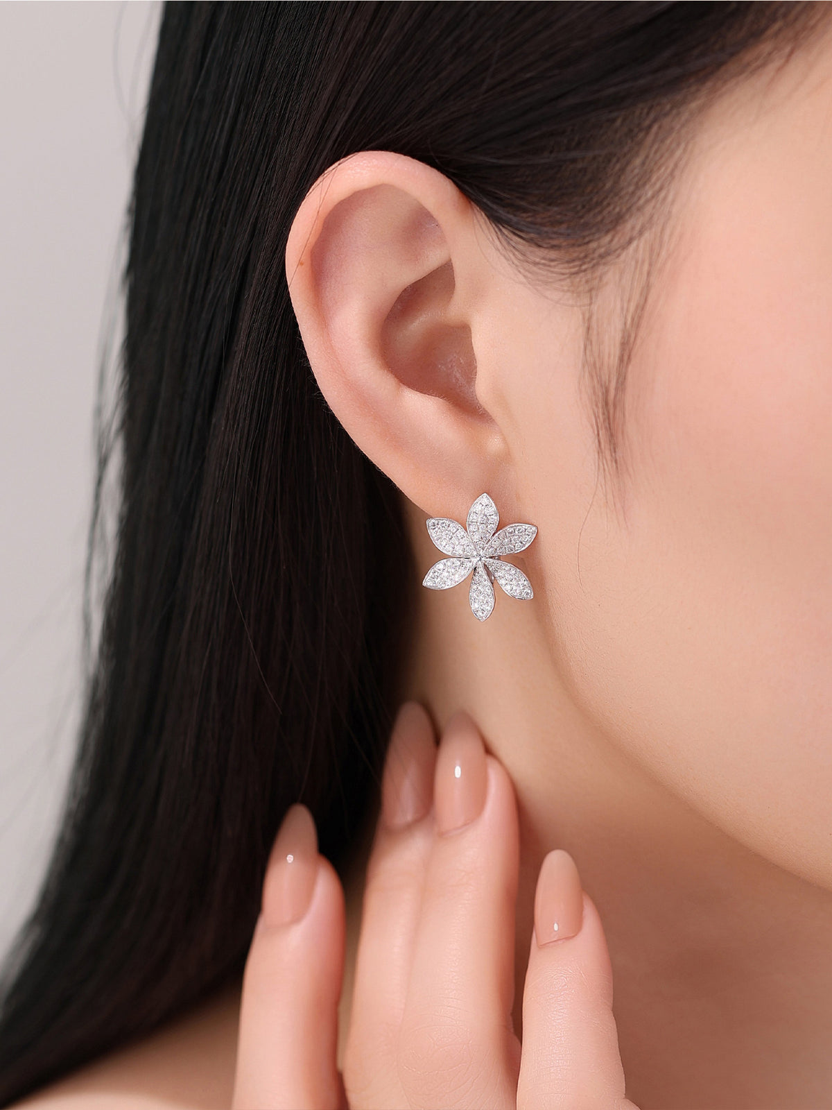Six-petal diamond flower earring worn, close-up