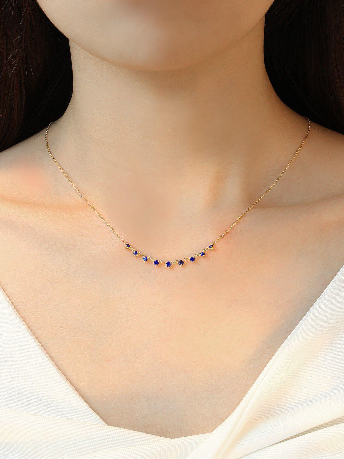 Model wearing the DANFÉE Nine-Stone Smile sapphire necklace