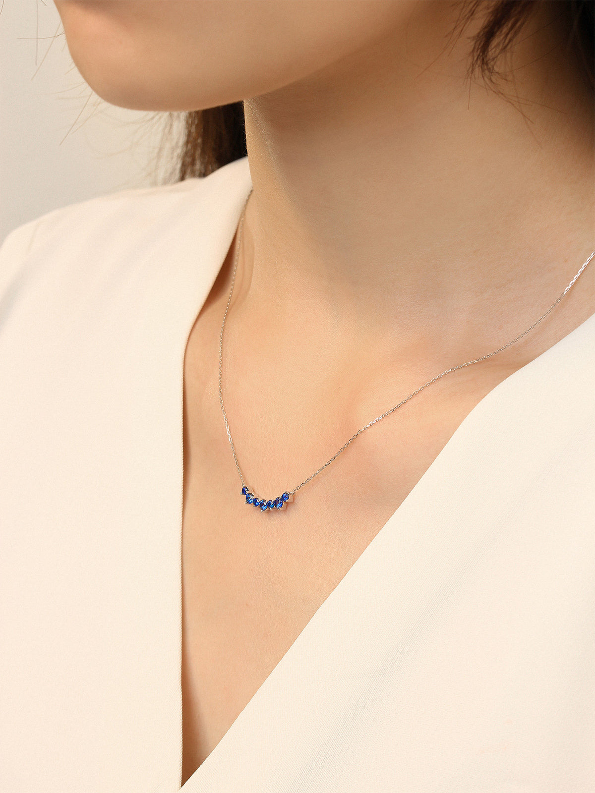 Model wearing the DANFÉE Seven-Stone Smile sapphire necklace