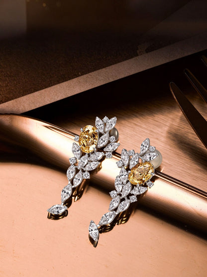 Fancy yellow lab-grown diamond drop earrings with marquise diamonds resting on rose gold surface